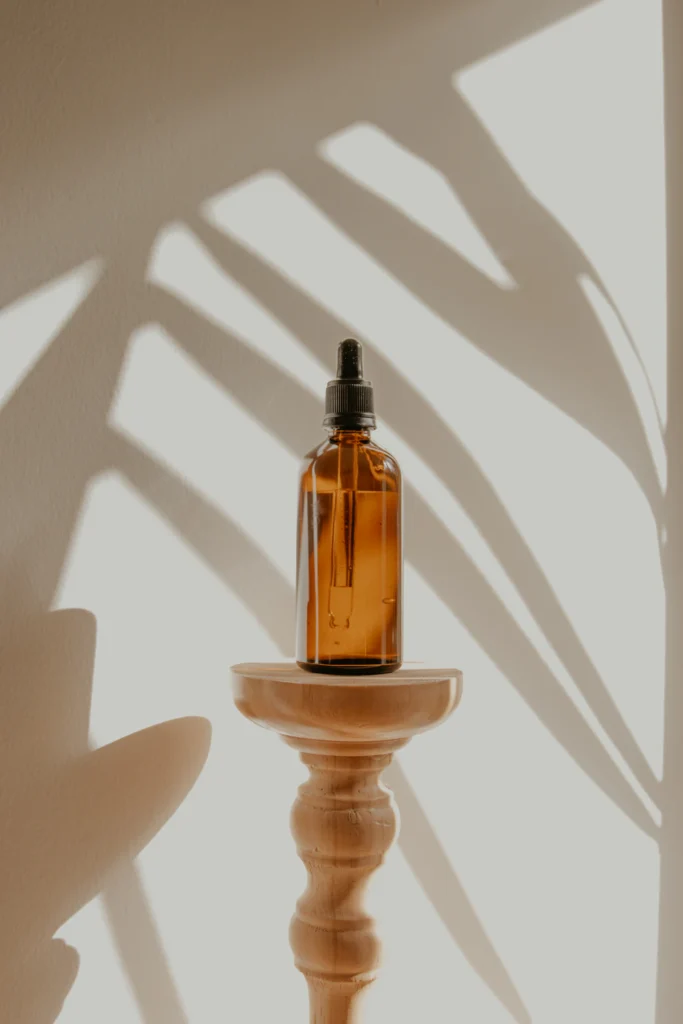 Amber dropper bottle on a wooden pedestal