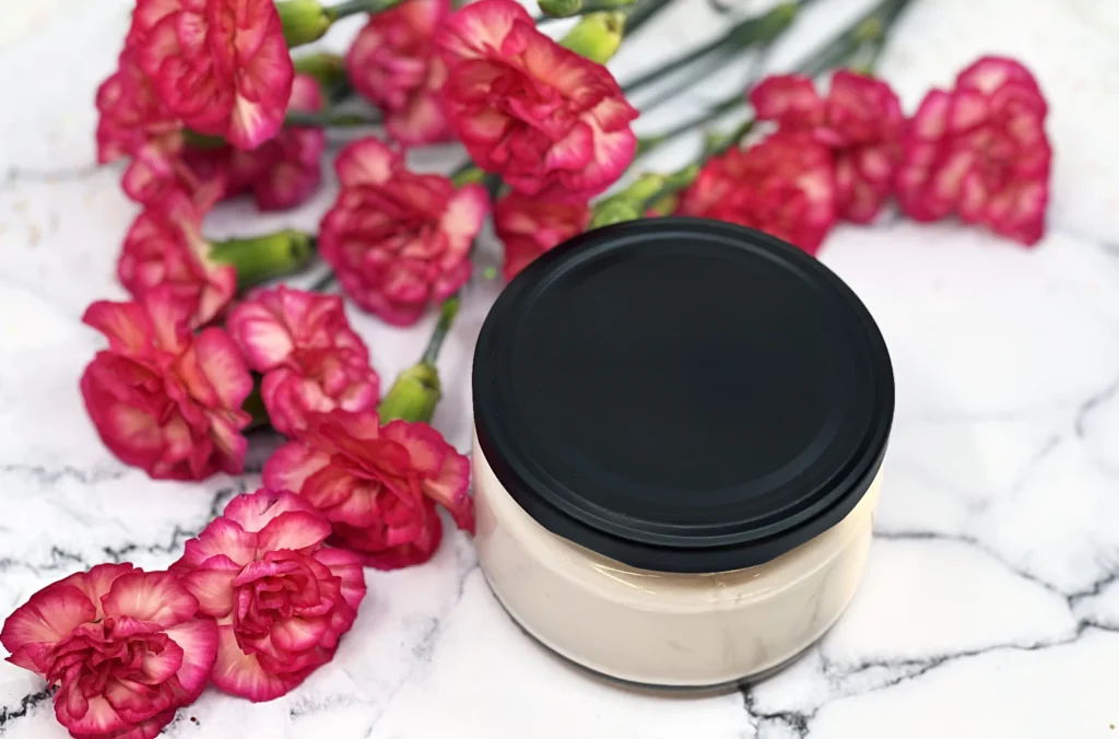 Cream jar with pink flowers on marble