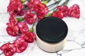 Cream jar with pink flowers on marble
